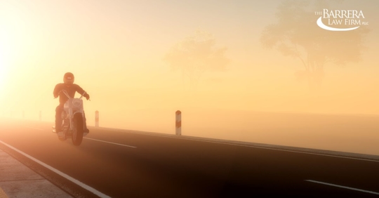 Person riding motorcycle at sunset in fog